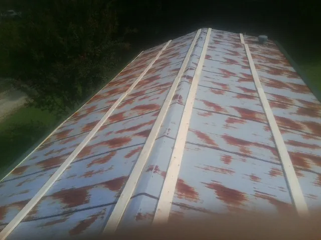 Rusted metal roof panels with new wood purlins before replacement — Storm Damage Roof Repair in Northampton by Roofing Brothers