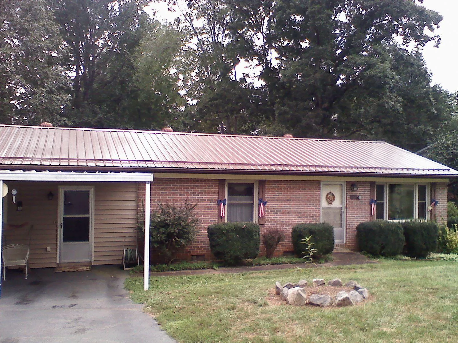 Bronze metal roof and carport on a brick ranch home — Roof Repair work by our crew in Northampton